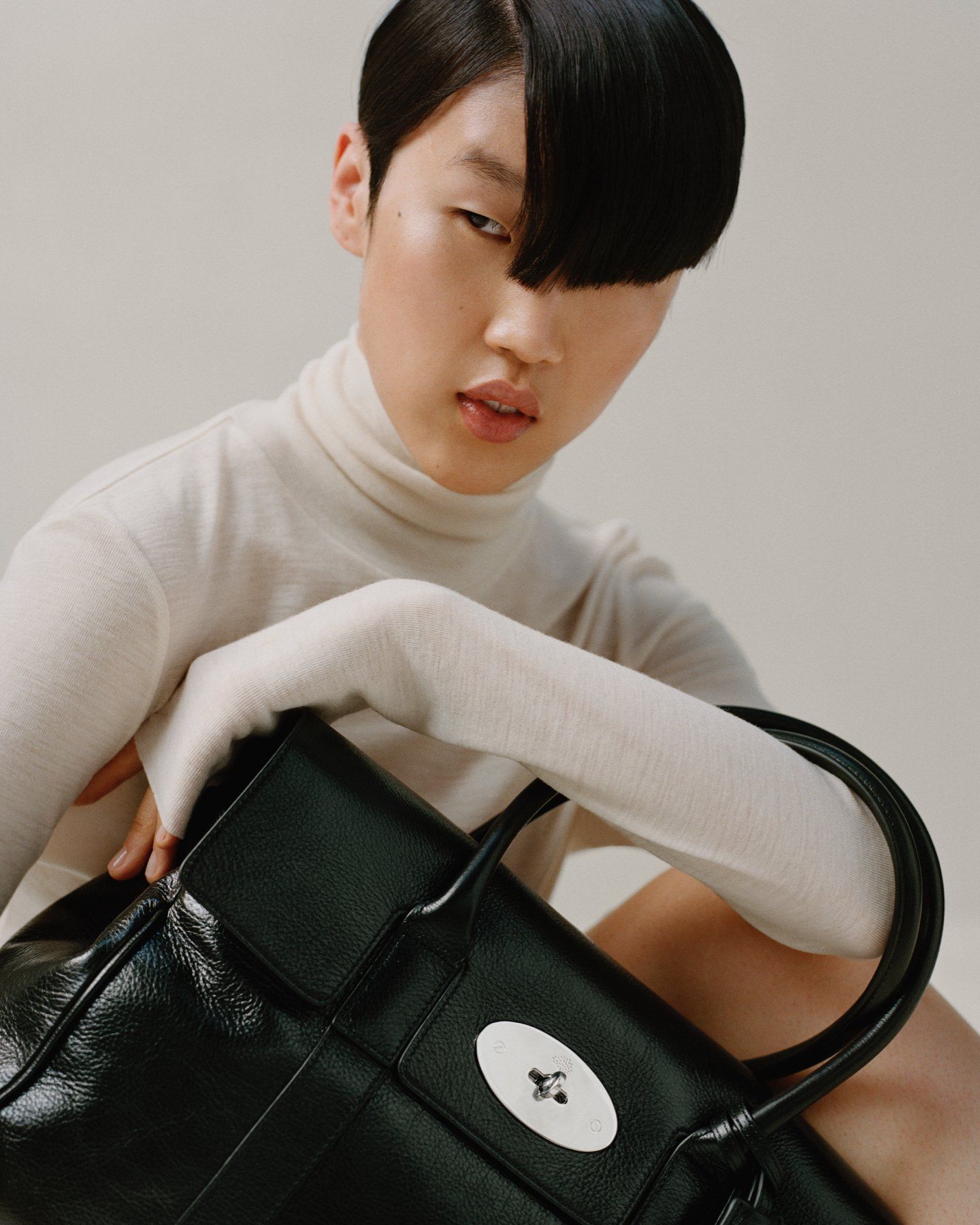 model wearing mulberry bayswater bag in black high shine leather